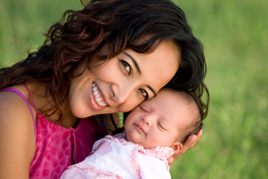 woman smiling holding a baby