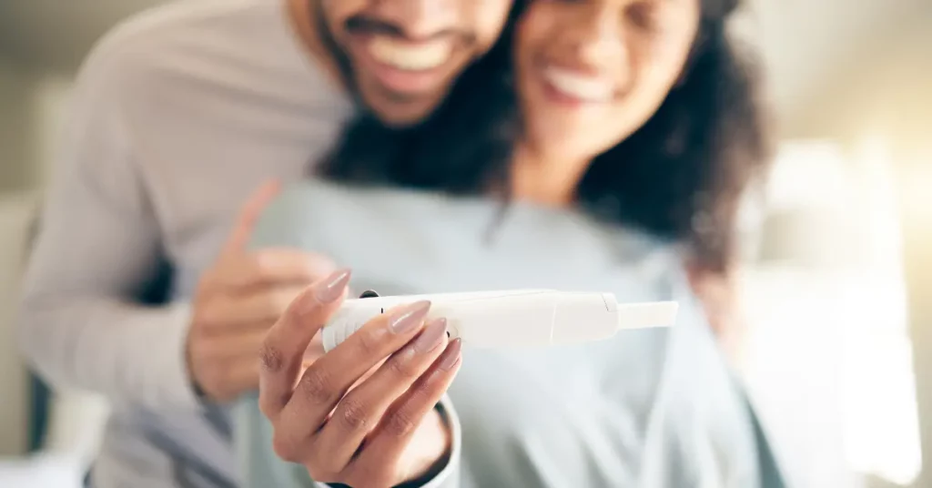 IVF clinic couple happily looking at positive pregnancy test in bright home setting.