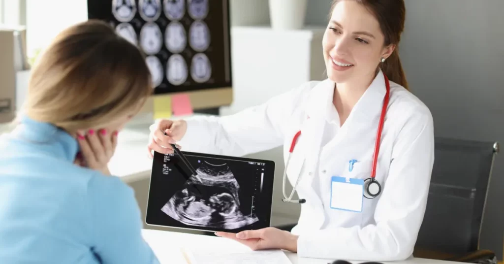 Fertility clinic doctor showing ultrasound image to woman during medical consultation.