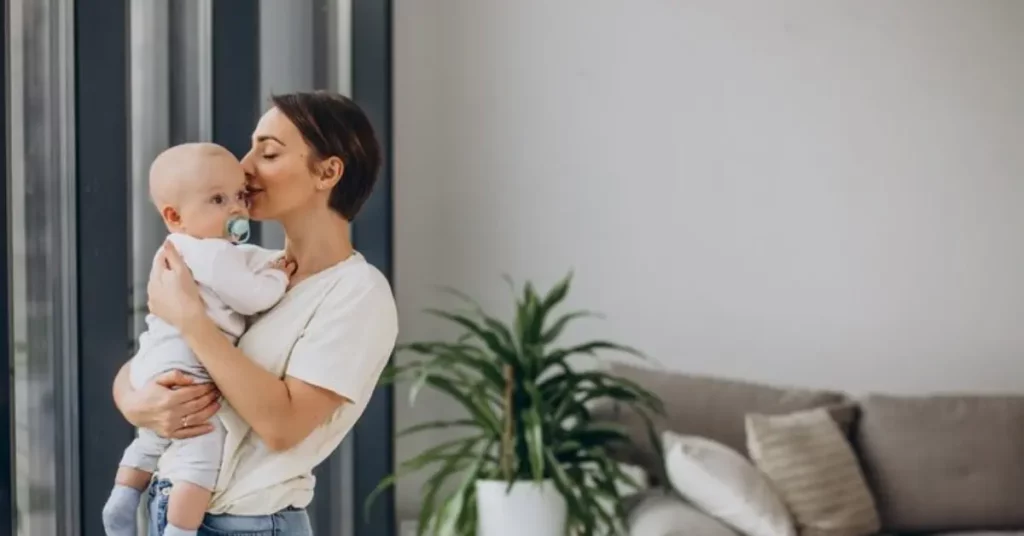 Fertility treatment success shown by a mother holding and kissing her baby in a cozy living room