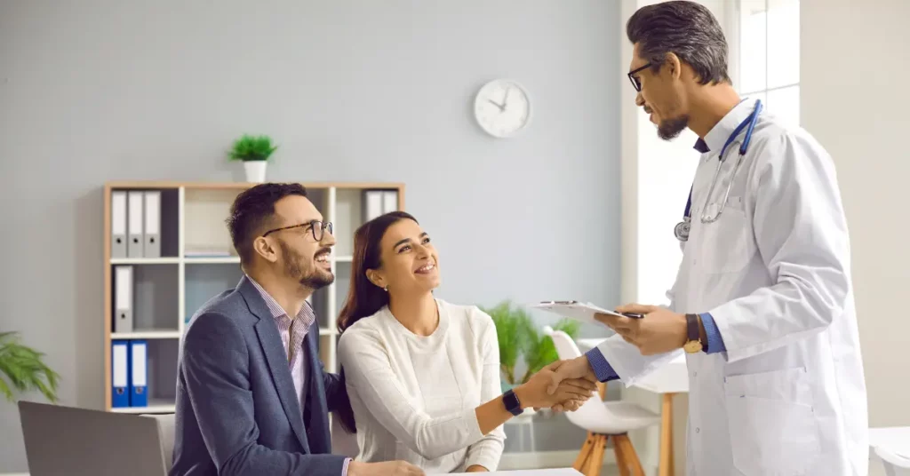 Ovarian reserve test discussion between a couple and doctor, with a clipboard and documents in a professional setting.