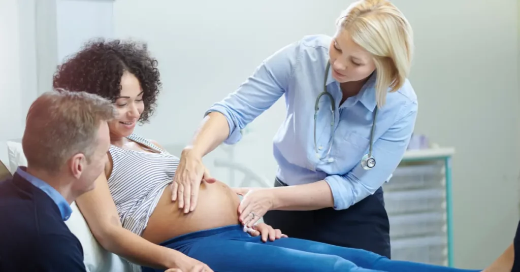 Low-dose IVF checkup showing a pregnant woman being examined by a doctor while her partner supports her.