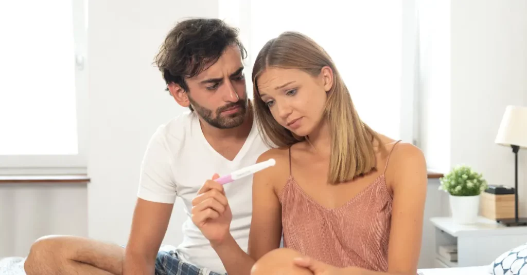 Fertility treatment options discussed by a worried couple looking at a negative pregnancy test.