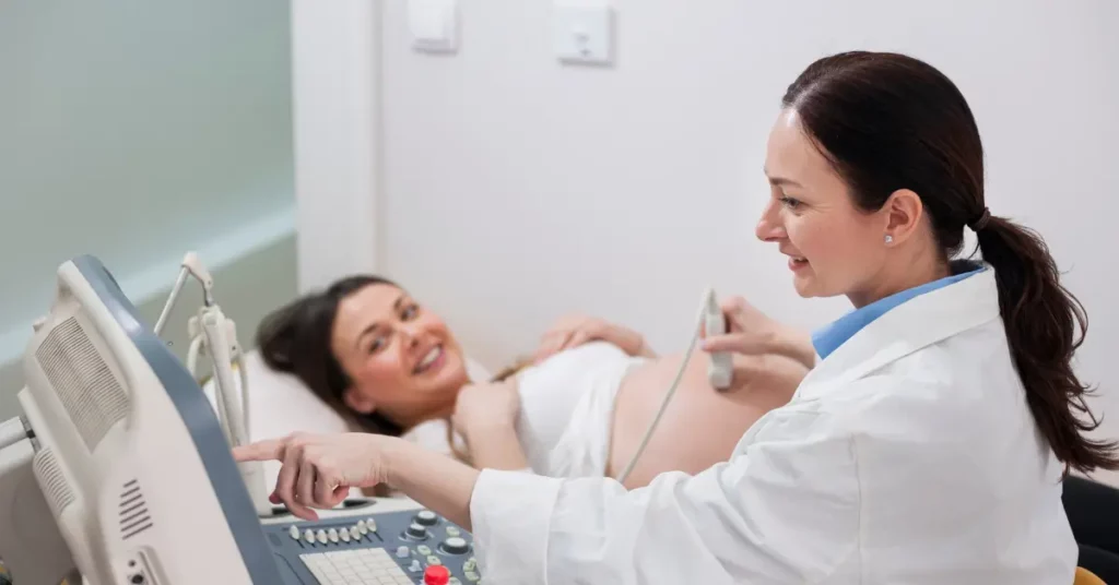 Fertility clinic visit with a smiling pregnant woman receiving an ultrasound from a female doctor.