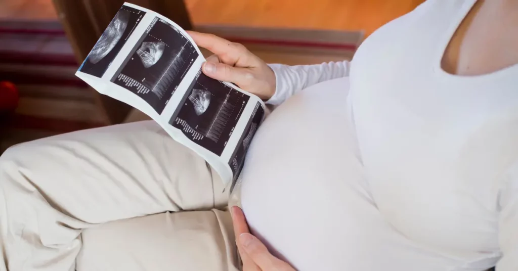 Prenatal nutrition represented by a pregnant woman viewing ultrasound images on her lap.


